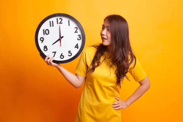 Młoda kobieta azjatyckich z zegarem w żółtej sukience — Zdjęcie stockowe