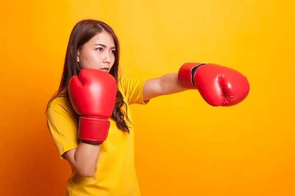Mujer asiática joven con guantes de boxeo rojos en vestido amarillo —  Fotos de Stock
