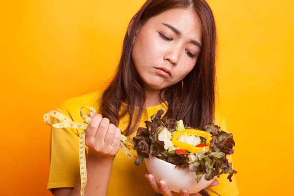 Ongelukkig Aziatische vrouw met het meten van de tape en salade met gele Quest — Stockfoto