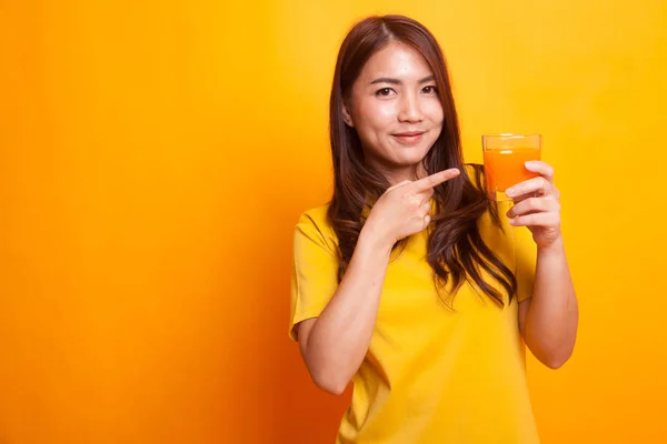 Młoda kobieta azjatyckich punkt do soku pomarańczowego w żółtej sukience — Zdjęcie stockowe