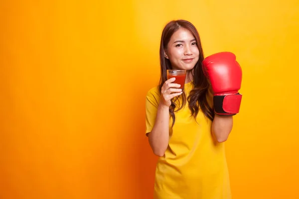 Joven mujer asiática con jugo de tomate y guante de boxeo en amarillo d —  Fotos de Stock