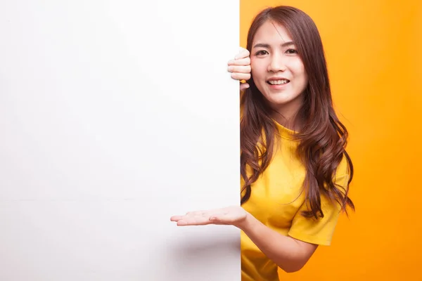 Jonge Aziatische vrouw aanwezig leeg bord met palm hand in gele dr — Stockfoto