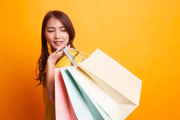 黄色のドレスのショッピング バッグに満足して若いアジア女性 — ストック写真