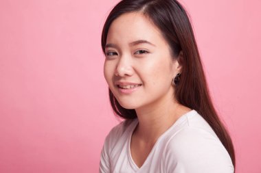 Pembe arka plan gülümseyen güzel genç Asyalı kadın