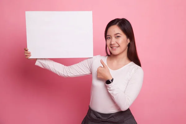 Junge asiatische Frau zeigen Daumen nach oben mit weißen leeren Zeichen. — Stockfoto