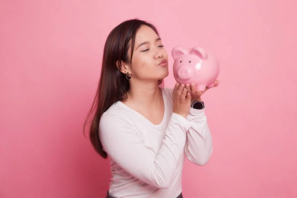 Mladá asijská žena kiss růžová mince banka. — Stock fotografie