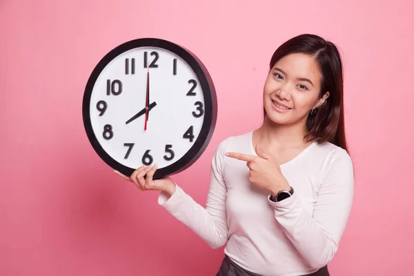 Młoda kobieta azjatyckich wskaż zegar. — Zdjęcie stockowe