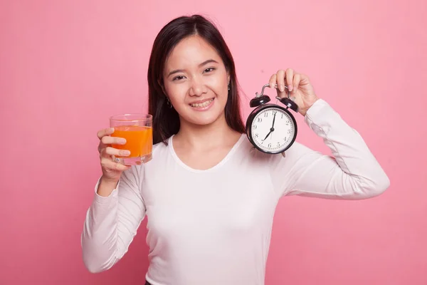 Mujer asiática con un reloj beber jugo de naranja . — Foto de Stock