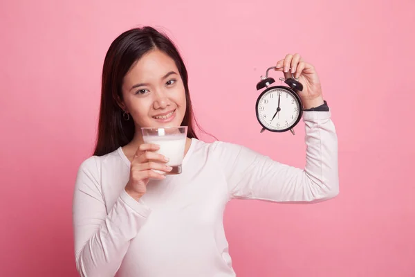 Saludable mujer asiática bebiendo vaso de leche celebrar reloj . — Foto de Stock