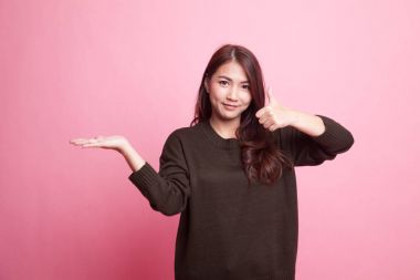 Güzel genç Asyalı kadın göstermek palm el ve başparmak yukarıya.