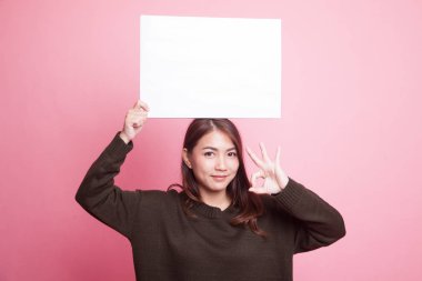 Genç Asyalı kadın göster Tamam beyaz boş işaretiyle.