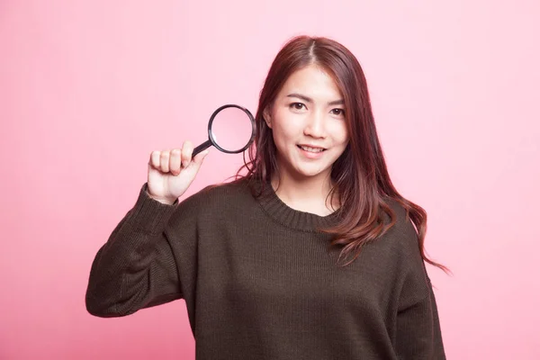 Young Asian woman with a magnifying glass. — Stock Photo, Image