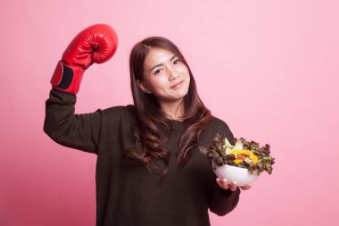 Genç Asyalı kadın boks eldiven ve salata ile.