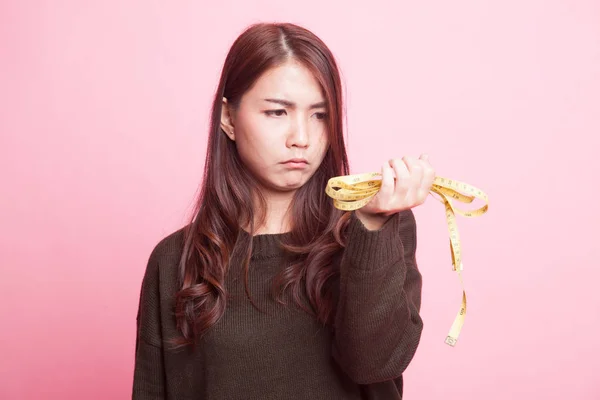 Unhappy young Asian woman with measuring tape. — Stock Photo, Image