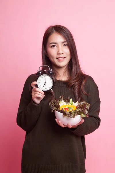 Jonge Aziatische vrouw met klok en salade. — Stockfoto