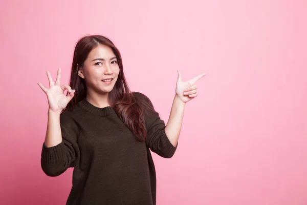 Young Asian woman point and show OK. — Stock Photo, Image