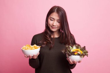 Patates kızartması ve salata ile genç Asyalı kadın.