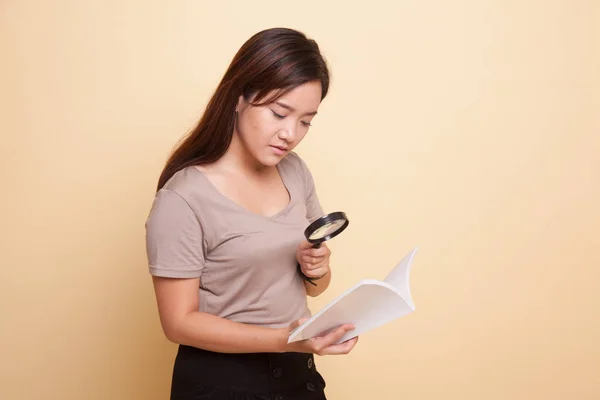 Mulher asiática com um livro e lupa . — Fotografia de Stock
