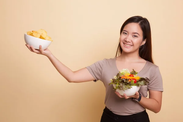 Jovem mulher asiática com batatas fritas e salada . — Fotografia de Stock