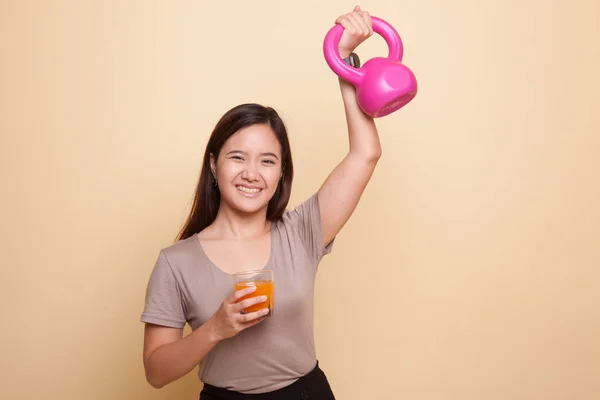 Giovane donna asiatica con kettlebell bere succo d'arancia . — Foto Stock