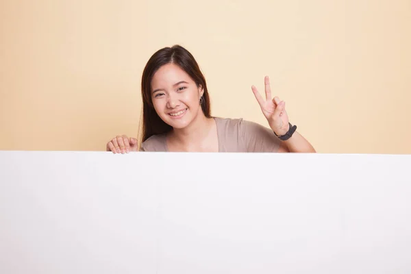 Giovane donna asiatica mostra segno di vittoria con segno bianco . — Foto Stock