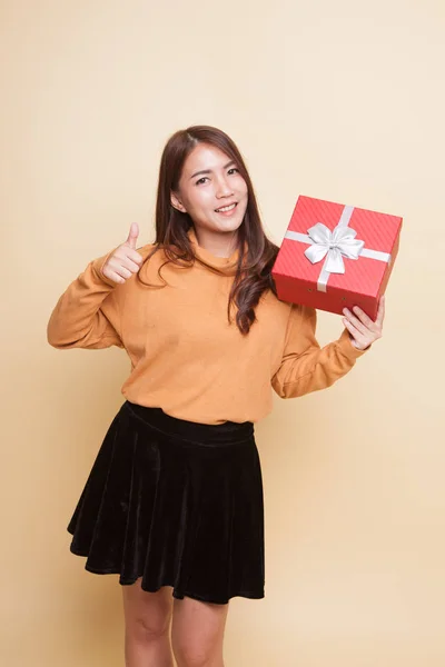 Азиатка поднимает большой палец с подарочной коробкой . — стоковое фото