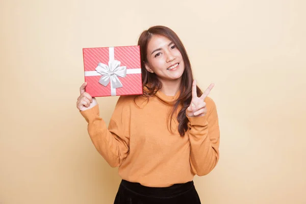 Asian woman show victory sign with a gift box. — Stock Photo, Image