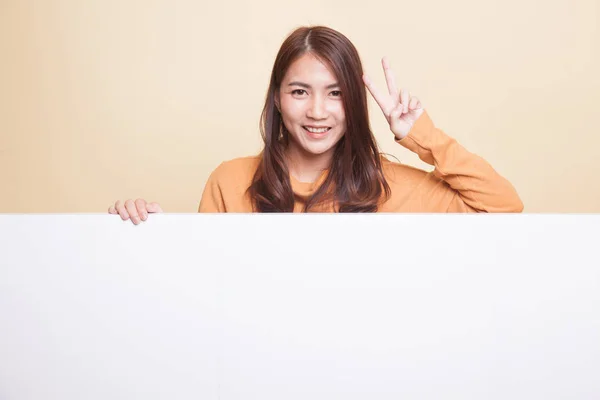 Молодая азиатка показывает знак победы с пустым знаком . — стоковое фото