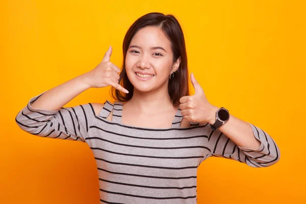 Junge asiatische Frau Daumen nach oben zeigen mit Telefon-Geste. — Stockfoto
