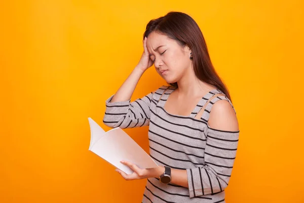 Giovane donna asiatica ha avuto mal di testa leggere un libro . — Foto Stock