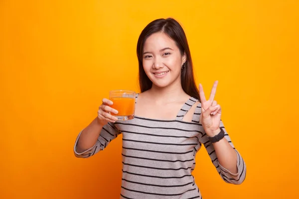 Fiatal ázsiai nő Térkép győzelem jele narancs ital gyümölcslé. — Stock Fotó