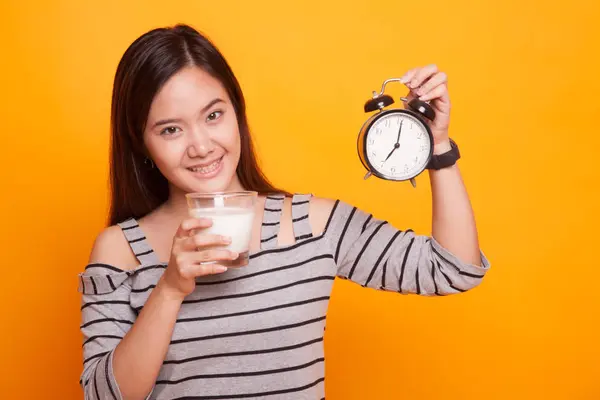 アジアの女性の健康的な牛乳のコップを保持時計. — ストック写真