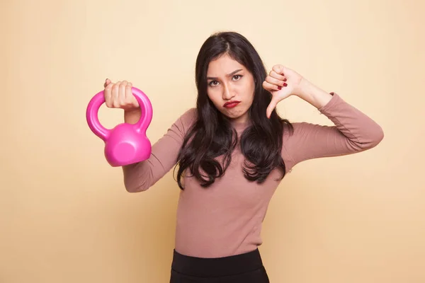 Unhappy Asian woman thumbs down with dumbbells.