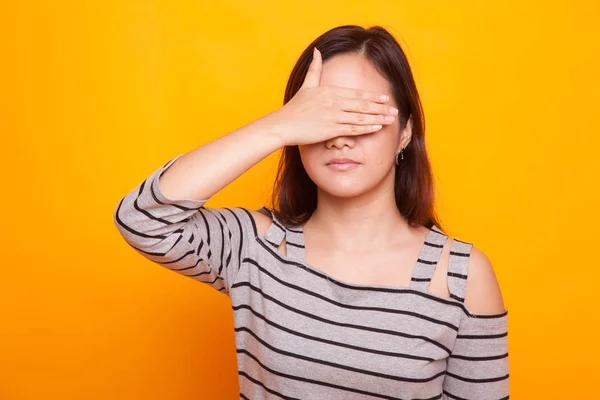 Junge asiatische Frau schließt ihre Augen mit der Hand. — Stockfoto