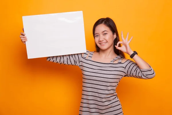 Молодая азиатка показывает ОК с белым пустым знаком . — стоковое фото