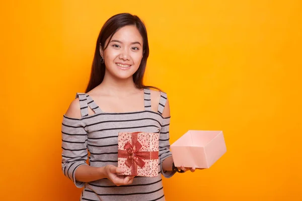 Junge asiatische Frau öffnet eine goldene Geschenkschachtel. — Stockfoto