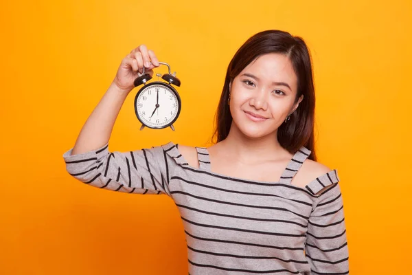 Jeune femme asiatique avec une horloge. — Photo