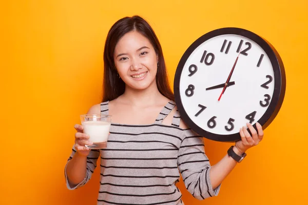 Saludable mujer asiática bebiendo vaso de leche celebrar reloj . — Foto de Stock