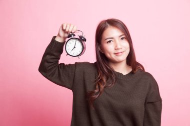 Saati olan genç Asyalı kadın..