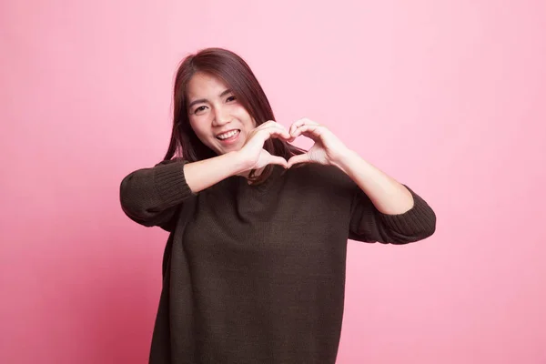 Young Asian woman show heart hand sign. — Stock Photo, Image