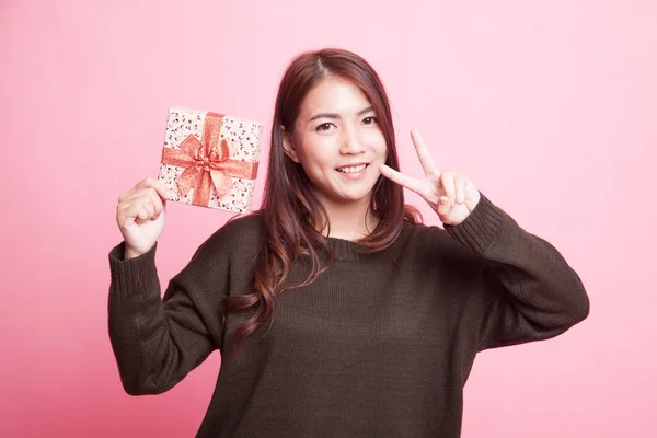 Asian woman show victory sign with a gift box. — Stock Photo, Image