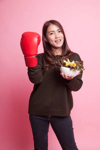 Jovem mulher asiática com luva de boxe e salada . — Fotografia de Stock