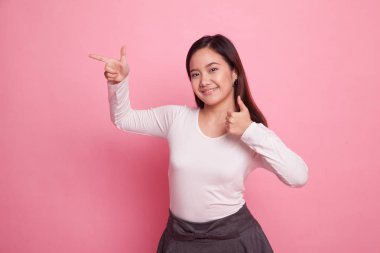 Genç Asyalı kadın noktası ve başparmak yukarıya.