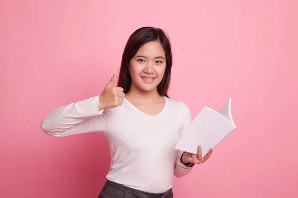 Jonge Aziatische vrouw duimen omhoog met een boek. — Stockfoto