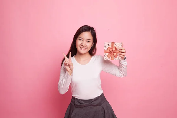 Азіатський жінка Показати знак перемоги з подарунковій коробці. — стокове фото