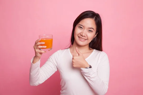 Jonge Aziatische vrouw duimschroef opwaarts drankje oranje sap. — Stockfoto