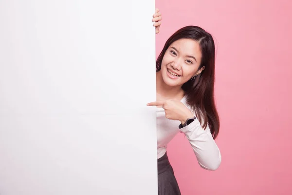 Junge asiatische Frau zeigt auf ein leeres Schild. — Stockfoto