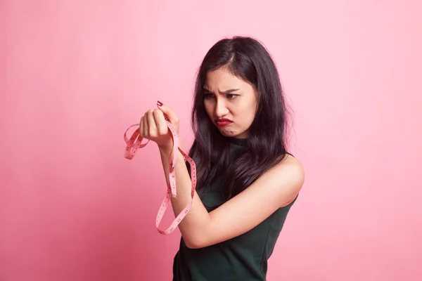 Infeliz joven mujer asiática con cinta métrica . — Foto de Stock