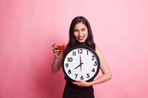 Young Asian woman with tomato juice and clock. — Stock Photo, Image