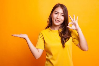 Güzel genç Asyalı kadın göstermek palm el ve Ok işareti.